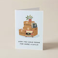 A folded greeting card standing upright on a beige surface. The card features an illustration of stacked vinyl records and boxes labeled 'VINYLS' with a small potted plant, above the text 'NOW YOU HAVE ROOM FOR MORE VINYLS!'.