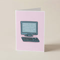 A pink greeting card standing upright on a beige surface, featuring a simple illustration of a computer and keyboard with the text 'THANK YOU FOR KEEPING ME FROM COMMITTING VIOLENCE IN THE WORKPLACE' on the screen.