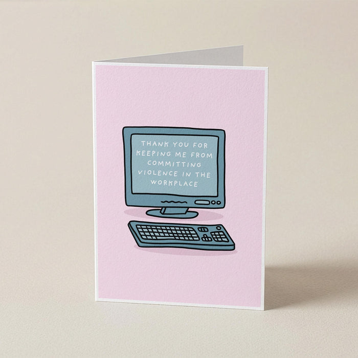 A pink greeting card standing upright on a beige surface, featuring a simple illustration of a computer and keyboard with the text 'THANK YOU FOR KEEPING ME FROM COMMITTING VIOLENCE IN THE WORKPLACE' on the screen.