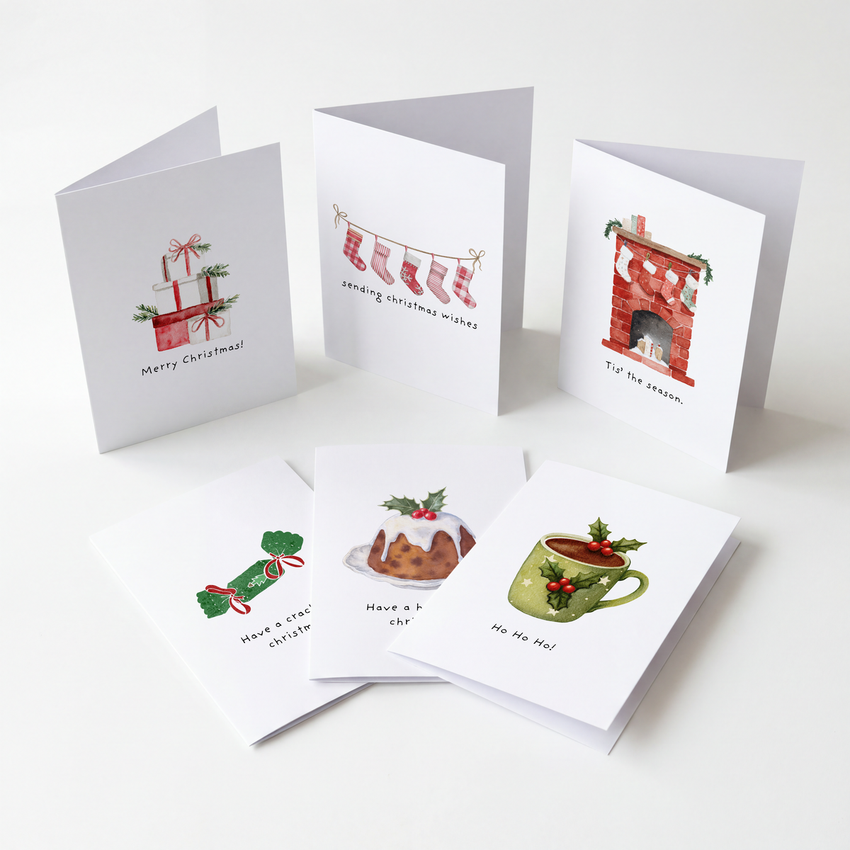 A set of illustrated Christmas greeting cards arranged on a clean white background. The cards show holiday scenes and messages including 'Merry Christmas!', 'sewing Christmas stockings', 'Tip the pot', 'Have a Christmas cookie', 'Have a nice Christmas', and 'Hot Tea at 6 pm'.